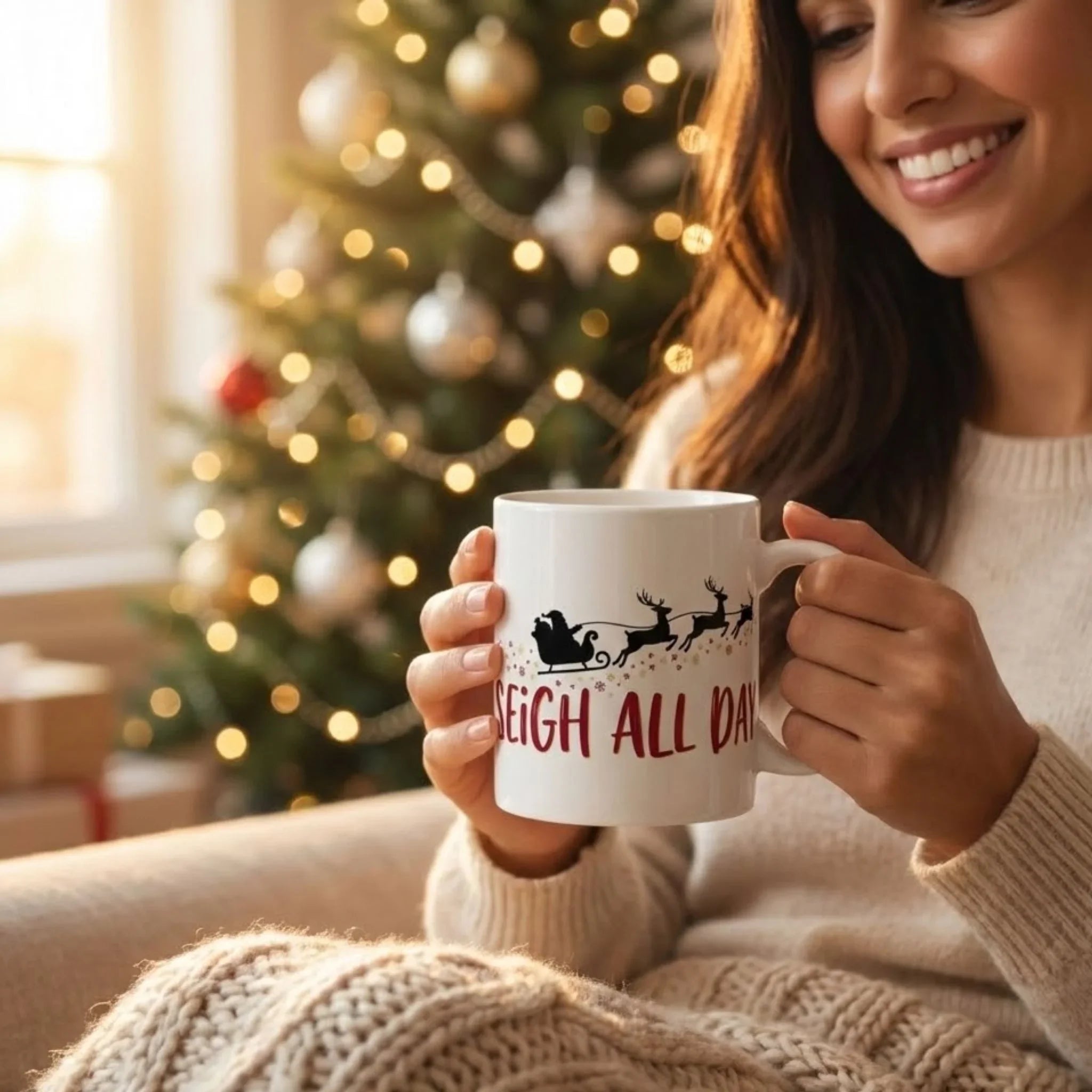 Woman holding a mug with a Christmas-themed design in front of a decorated tree.